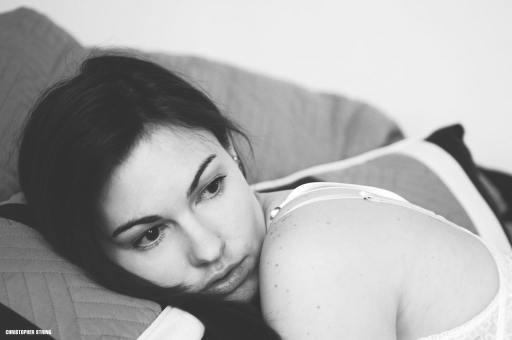 Intimate photo of woman laying on bed in black and white