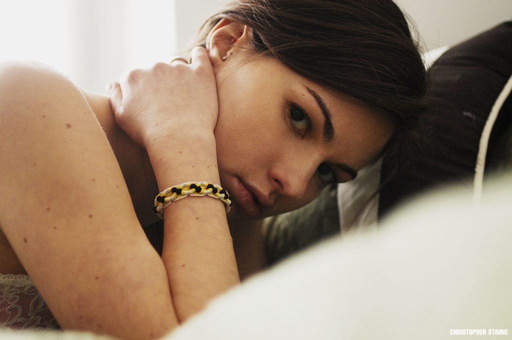 Woman looking at camera on bed